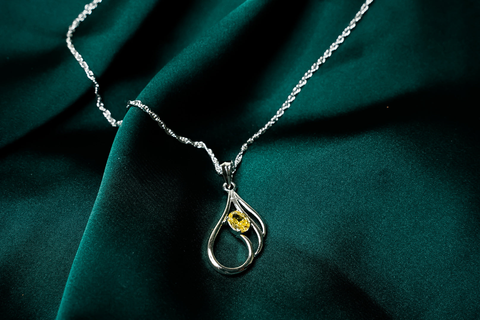 YELLOW SOLITAIRE HELD IN SILVER LOOPS