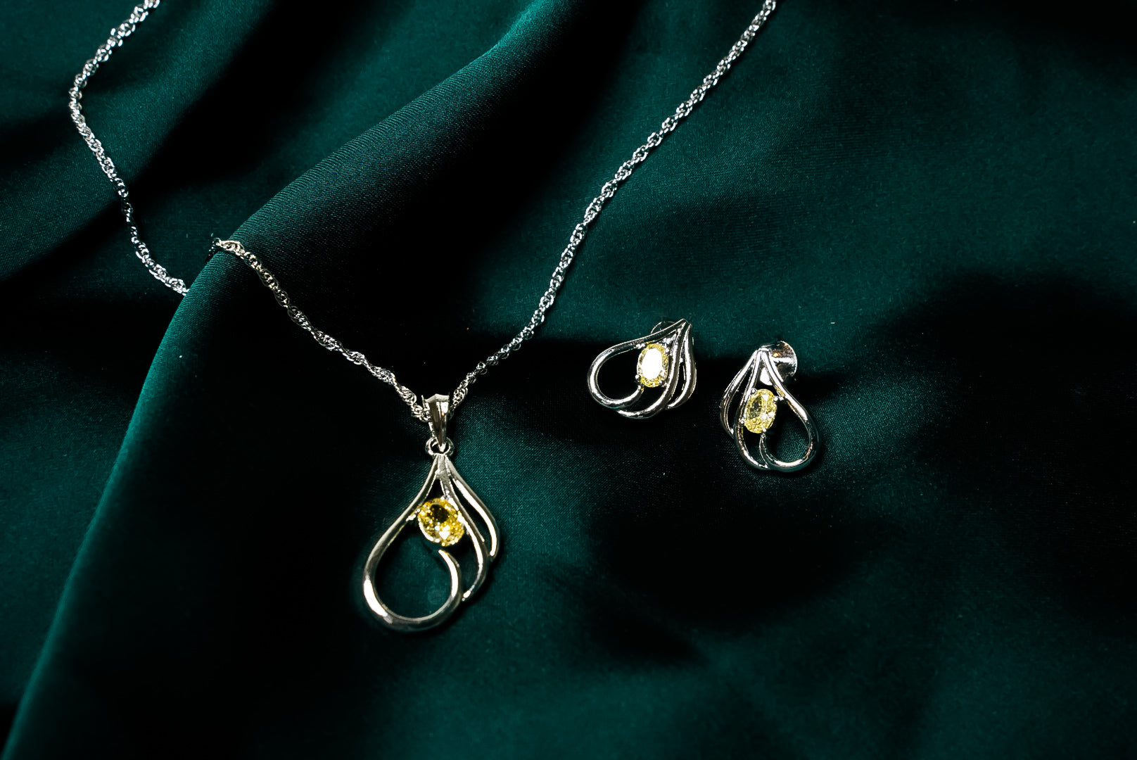 YELLOW SOLITAIRE HELD IN SILVER LOOPS